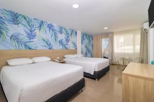 サン・アンドレスにあるHotel Bahia Sardinaのベッド2台とトロピカルな壁紙が備わるホテルルームです。