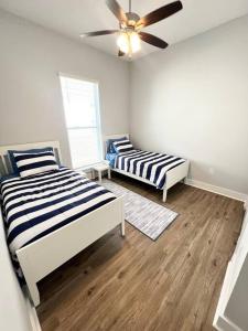 1 dormitorio con 2 camas y ventilador de techo en Coastal Oasis en Gulfport