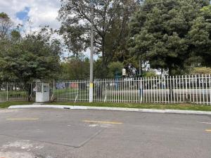 ein weißer Zaun neben einem Parkplatz in der Unterkunft apartamento cerca al aeropuerto my little home 6 in Bogotá