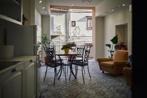 a living room with a table and chairs and a couch at Trinacria Caccamo - Luxury Rooms in Caccamo