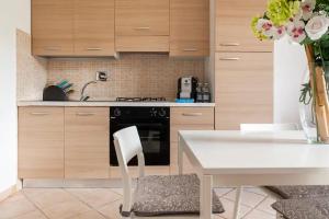 a kitchen with a white table and a white chair at Casa Nadia - Incantevole appartamento con giardino in Guardistallo +16 photos
