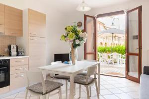 a kitchen with a white table with a vase of flowers at Casa Nadia - Incantevole appartamento con giardino in Guardistallo