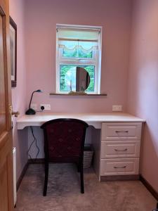 a desk with a mirror and a chair in a room at The Lodge Self Catering in Castlerea