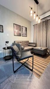 uma sala de estar com um sofá e uma cadeira em TheHideawaybyKG/Taytay em Malapandan