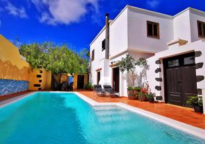 a villa with a swimming pool in front of a house at Casa-la-Costa in La Costa