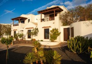 a large white house with trees and plants at Casa-la-Costa in La Costa