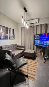 uma sala de estar com um sofá e uma televisão em TheHideawaybyKG/Taytay em Malapandan
