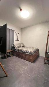 1 dormitorio con 1 cama y TV en TheHideawaybyKG/Taytay, en Malapandan