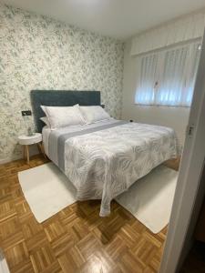 a bedroom with a bed and a wooden floor at Apartamento El Rinconín in Cangas de Onís