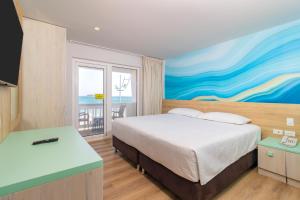 a bedroom with a bed and a painting on the wall at Hotel Bahia Sardina in San Andrés