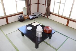 een kamer met een salontafel met een kruik erop bij Kinokuniya Ryokan in Fujisawa