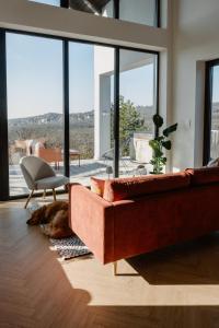 een woonkamer met een rode bank en een stoel bij SUQO vendégház in Sukoró