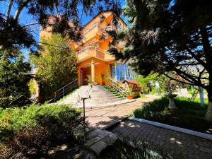 Una gran casa amarilla con escaleras delante. en Vila Egreta, en Eforie Nord