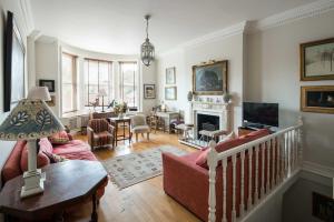a living room with a couch and a fireplace at Elegant 2-Bed Duplex with Patio nr Battersea Park in London