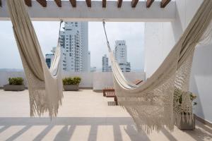 2 hamacas en un balcón con vistas a la ciudad en Tres habitaciones - Vista al Mar en Cartagena de Indias