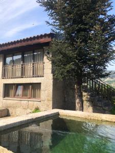 uma casa com piscina ao lado de uma árvore em Sobreiro Valley - Casa Isabel em Vieira do Minho