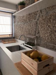 una cocina con una caja de fruta de madera en una encimera en Sobreiro Valley - Casa Isabel, en Vieira do Minho