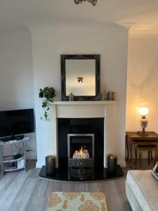 a living room with a fireplace with a mirror at Cosy 2 Double Bed Apartment in Swords