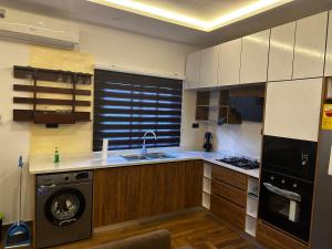 a kitchen with a sink and a dishwasher in it at Bobby’s villa in Accra