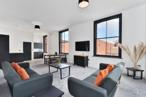 a living room with two couches and a tv at Apt 3, 15 West Street in Hereford