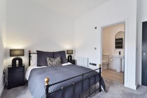 een slaapkamer met een zwart bed en een badkamer bij Apt 3, 15 West Street in Hereford