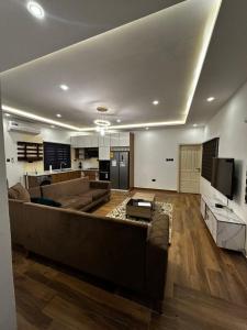 ein Wohnzimmer mit einem Sofa und einem TV in der Unterkunft Bobby’s villa in Accra