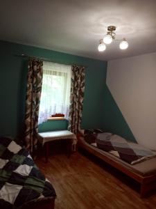 a bedroom with green walls and a window and two beds at Miodowe wzgórze in Jastrzębia