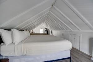 una camera da letto con letto bianco in mansarda di The Collins on Duval by Brightwild a Key West