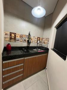 kuchnia ze zlewem i telewizor z płaskim ekranem w obiekcie Casa Lua Flat w mieście Brumadinho