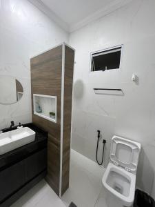 uma casa de banho branca com um lavatório e um WC em Casa Lua Flat em Brumadinho