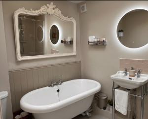 a bathroom with a sink and a tub and a mirror at Contented Cottage - 2 Bedrooms, Zone 5 in Buckhurst Hill