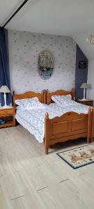 Schlafzimmer mit einem Bett und einem Wandspiegel in der Unterkunft Maison Colleville-Montgomery - Bord de mer in Colleville-Montgomery