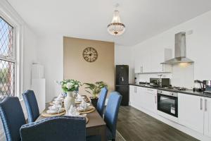 a dining room with a table and chairs and a kitchen at Home In Woodhouse, Leeds in Leeds