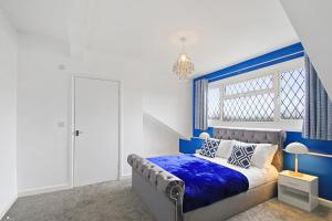 a blue and white bedroom with a bed and a window at Home In Woodhouse, Leeds in Leeds