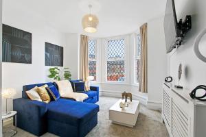 a living room with a blue couch and a window at Home In Woodhouse, Leeds in Leeds