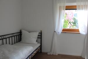 a small bedroom with a bed and a window at Haus & Garten bis zu 6 Personen! in Rosenheim