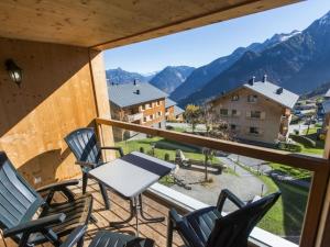 a balcony with chairs and a table and mountains at Landal Brandnertal in Bürserberg