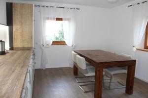 Il comprend une cuisine avec une table en bois et du parquet. dans l'établissement Haus & Garten bis zu 6 Personen!, à Rosenheim