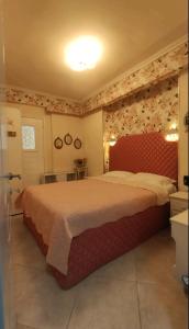 a bedroom with a large bed with a red headboard at Blue Beach Siviri Chalkidiki in Siviri