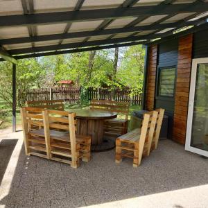 een patio met een tafel en stoelen op een huis bij Metkina Hiška 