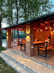 een paviljoen met een picknicktafel op een terras bij Rustic Luxury Villa Drina Drlače in Ljubovija