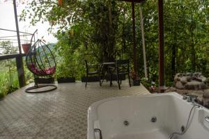 a bathroom with a tub and a table and chairs at GLAMPING MINDO SUYANA in Mindo