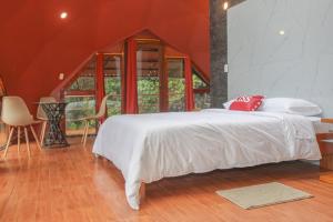 a bedroom with a bed and a table and chairs at GLAMPING MINDO SUYANA in Mindo