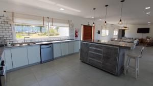 a large kitchen with white cabinets and a large island at Casa Paradiso in Coronel Moldes