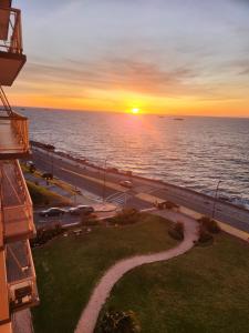 einen Sonnenuntergang über dem Meer vom Balkon eines Gebäudes in der Unterkunft Hermoso 2 ambientes en la costa con vista al mar in Mar del Plata