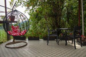 un patio con sillas, un columpio y una mesa en GLAMPING MINDO SUYANA en Mindo