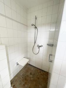 a white tiled bathroom with a shower and a toilet at Haus & Garten bis zu 6 Personen! in Rosenheim