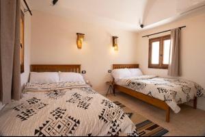two beds sitting next to each other in a bedroom at Sukoon Camp in Nuweiba