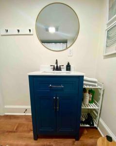 a bathroom with a blue cabinet and a mirror at Jewel Brook Cottage in Ludlow
