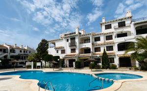 un immeuble avec une piscine devant un immeuble dans l'établissement Casa Refa en Cabo Roig, à Orihuela Costa